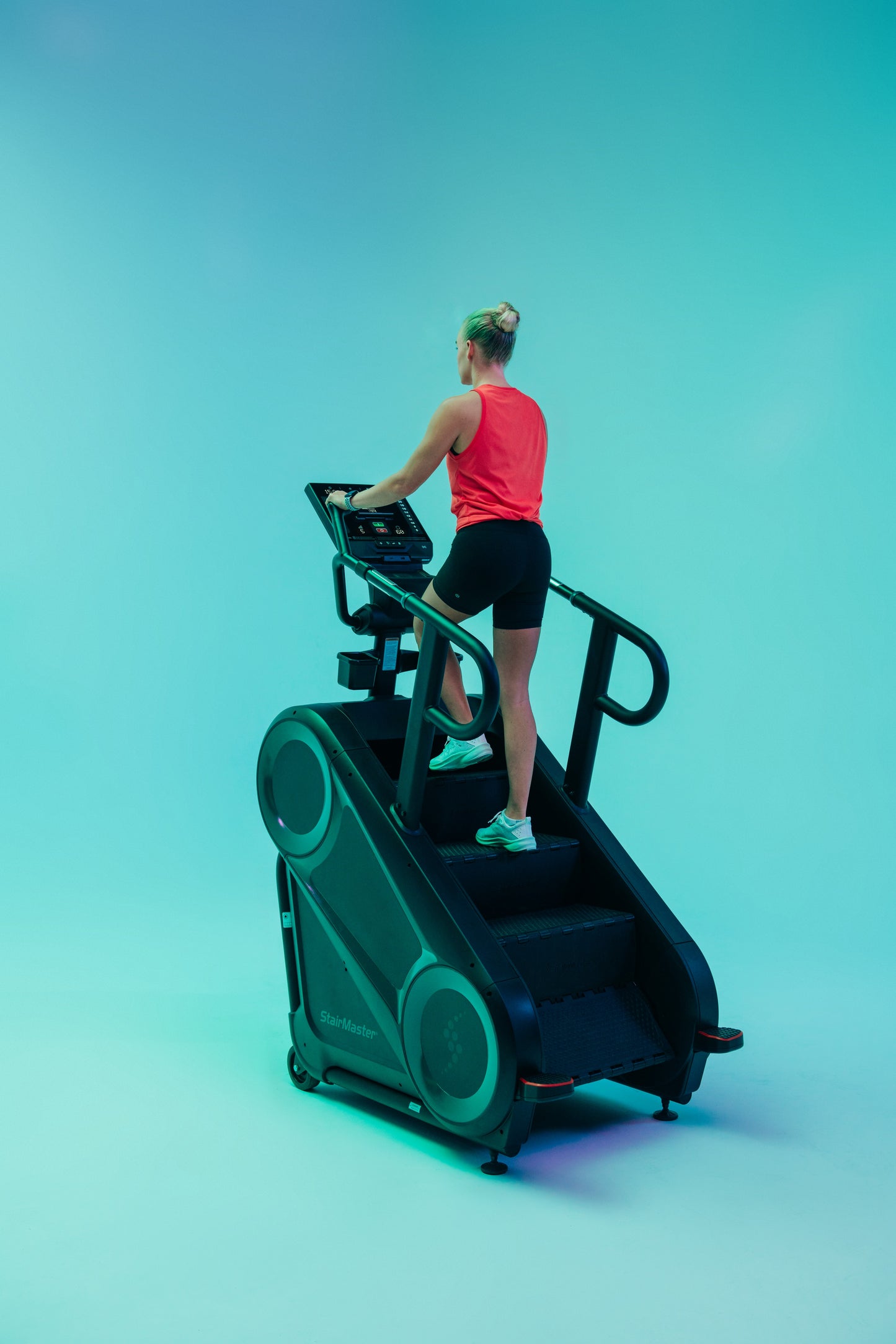 Person using a stair stepper machine on a gradient blue background