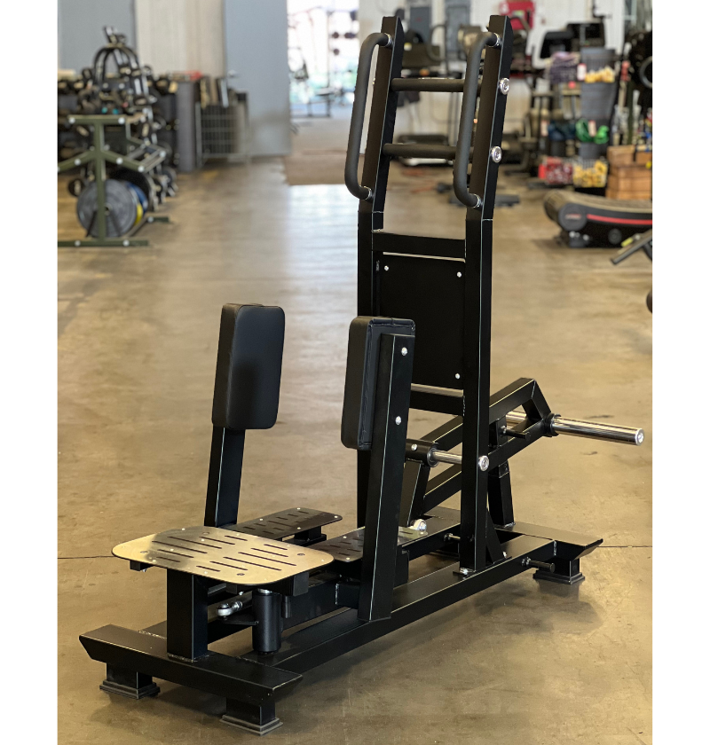 The J6503 Standing Abductor squat machine is prominently placed in the center of a large warehouse environment.