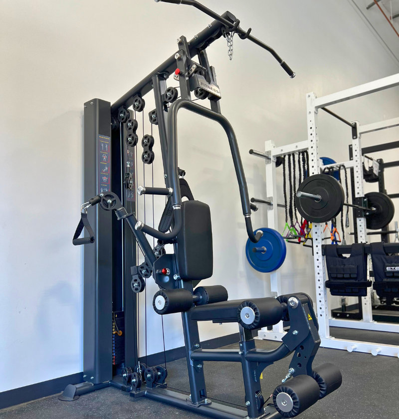 Single Station Gym machine positioned in a gym, ready for use in upper body strength training exercises.