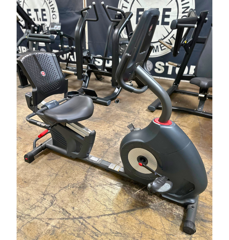 Exercise bike in a gym setting with other equipment in the background