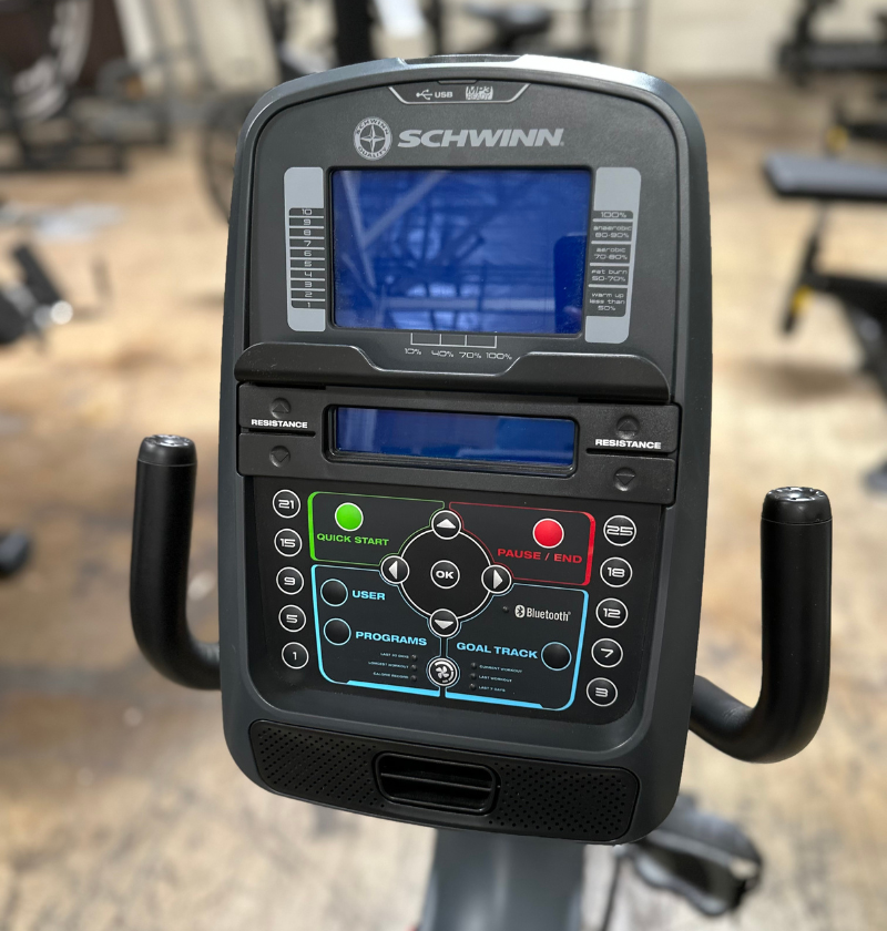 Close-up of a Schwinn exercise bike console with digital display and control buttons.