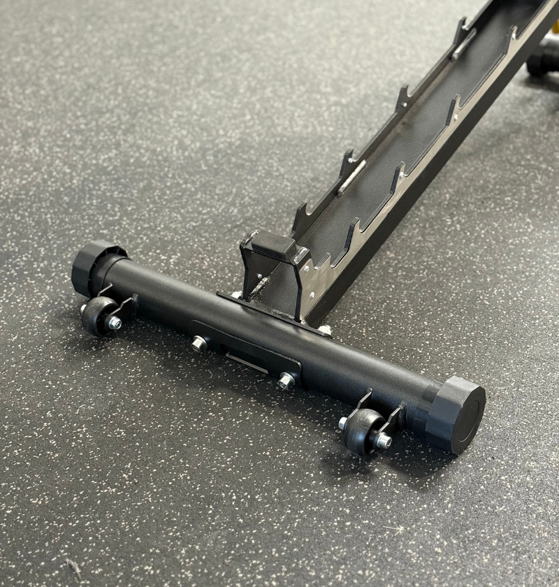 Black metal adjustable bench hinge with wheels displayed on a speckled rubber gym flooring
