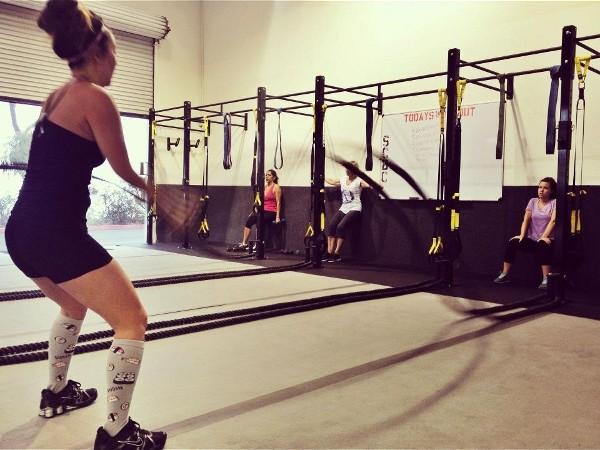 Woman using battle rope in gym setting