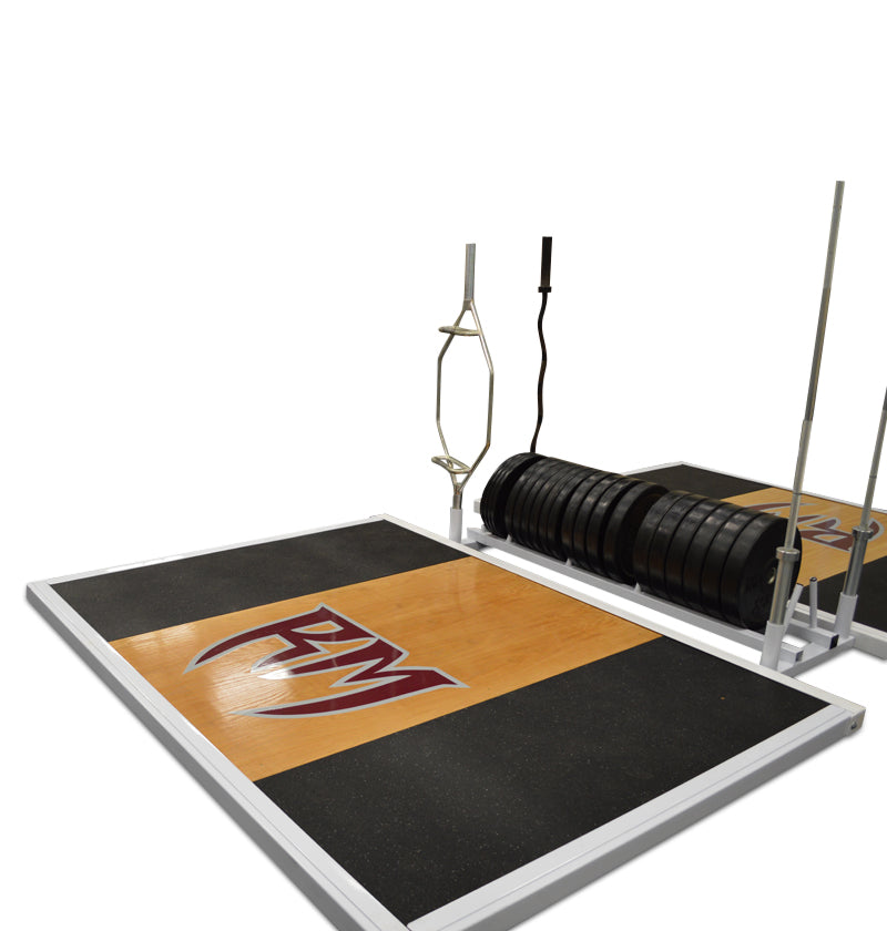 An Olympic lifting platform with a black and gold color scheme, featuring a logo on the end, accompanied by weightlifting equipment in the background.