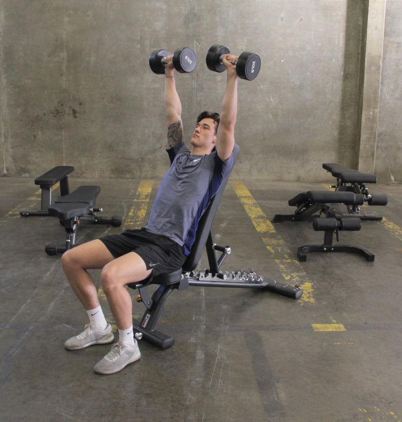 A man performs a dumbbell exercise on an Adjustable Flat Incline Bench PL7328, focusing on strength training.