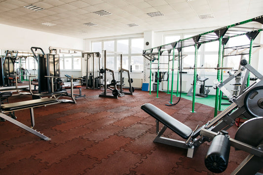  A well-equipped gym displaying a row of exercise machines and fitness equipment for training purposes.