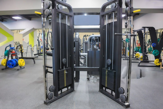  A large black and yellow functional trainer machine set up in a gym, designed for various strength training workouts.