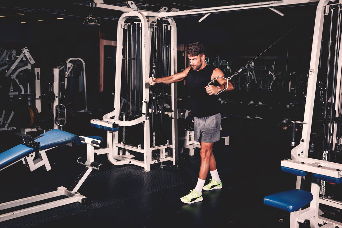 a man performs a pull-up on a gym machine, showcasing strength and fitness.