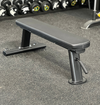 A black bench positioned in front of a horizontal bar, suitable for exercise or outdoor seating.