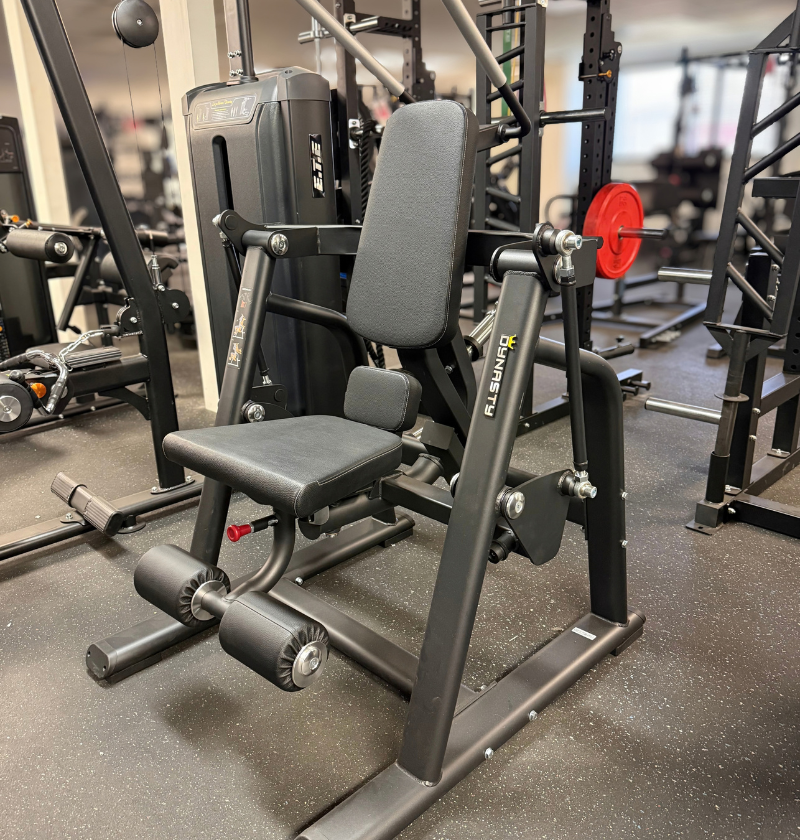A black plate loaded ab crunch gym machine in a fitness center setting.
