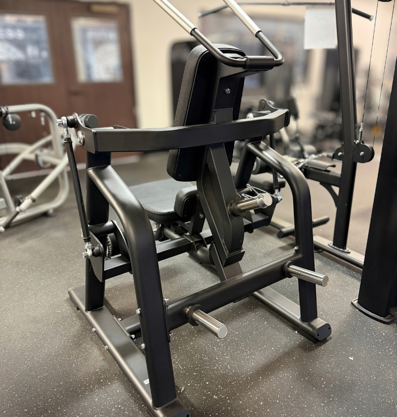 Rear photo of a black plate loaded ab crunch machine on a grey speckled floor.