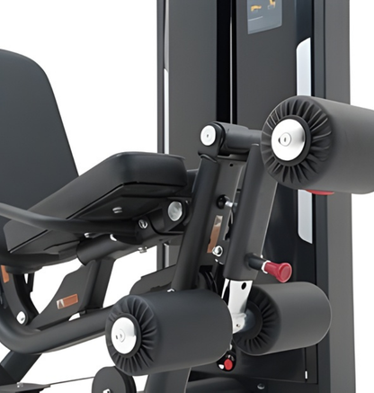 Close-up of a black leg extension prone leg curl machine with black padding and metallic components on a white background