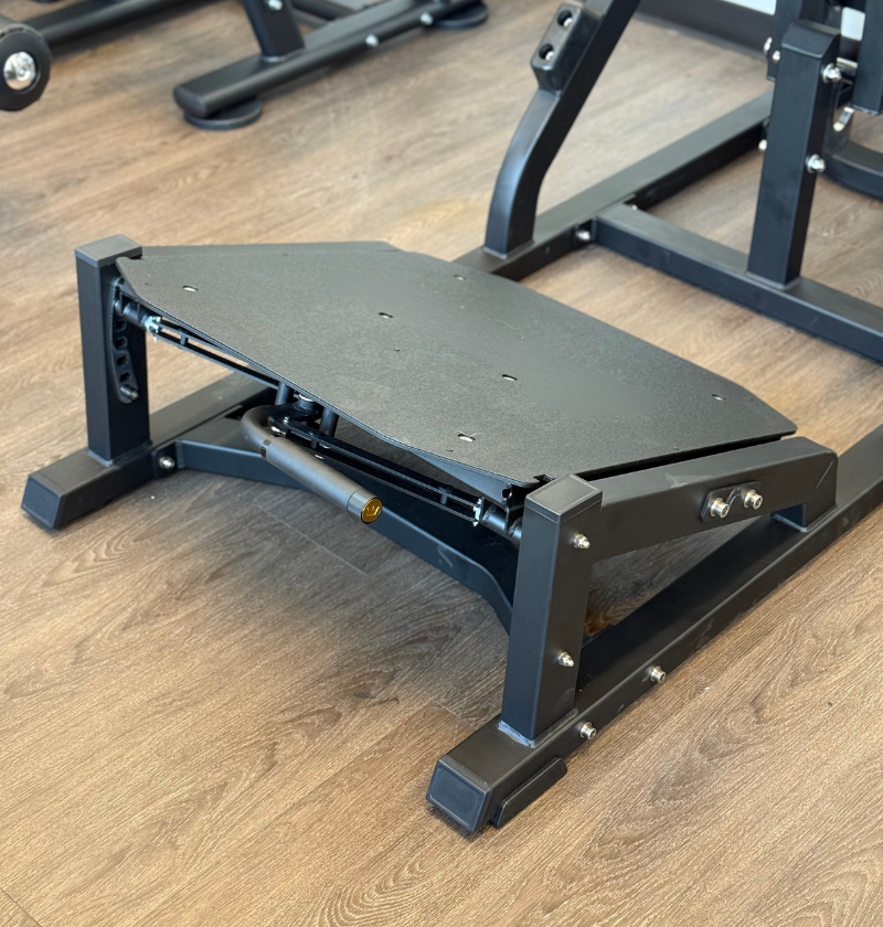 Front squat foot plate on a wood background.