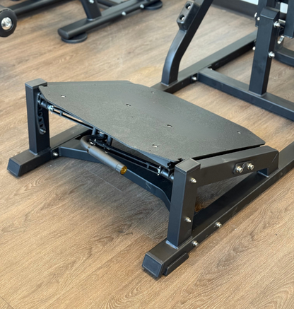 Front squat foot plate on a wood background.