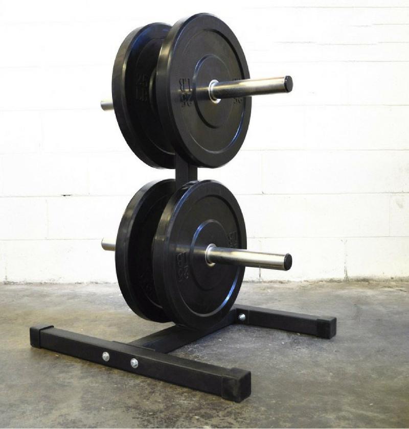 Two black bumper plates on a stand with two bar holders against a white wall.