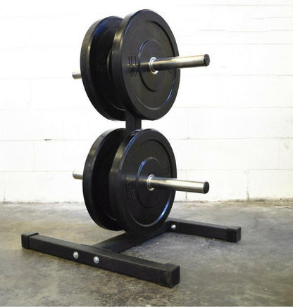Two black bumper plates on a stand with two bar holders against a white wall.